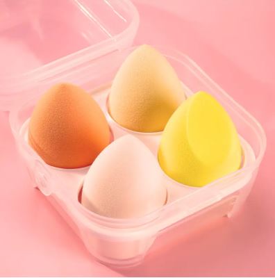 The My Store Éponge de maquillage (4 pièces) includes orange, beige, cream, and yellow sponges in a clear four-compartment case—ideal for flawless makeup application.