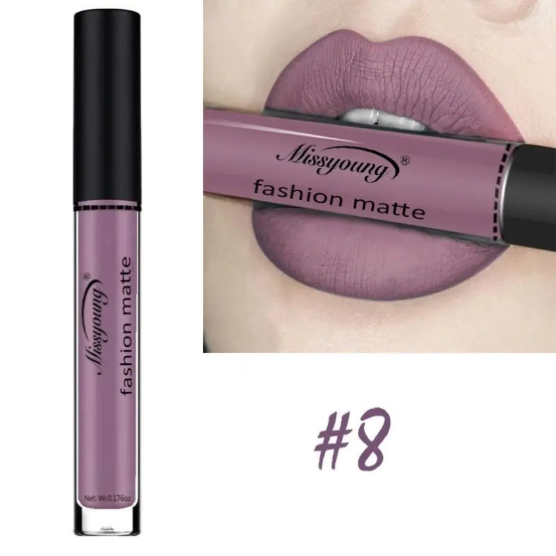 A tube of Léa Beauty & Cosmetics Non-Stick Matte Liquid Lipstick Lip Gloss Makeup in shade #8 is shown, with lips wearing the same mauve-purple matte formula, stylishly holding the tube between them.