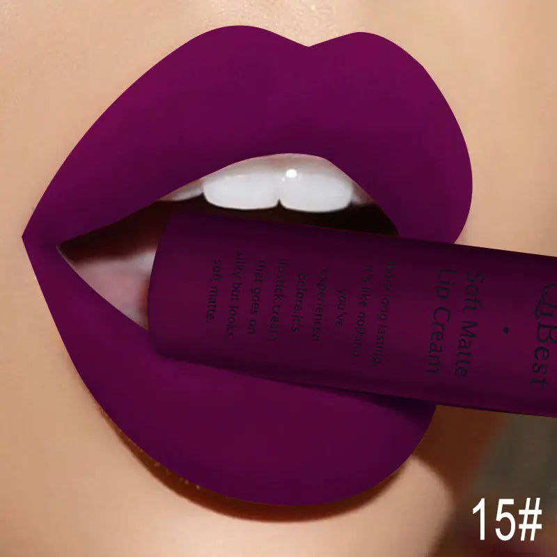 A close-up of lips in bold, matte purple, slightly parted to hold a Léa Beauty & Cosmetics Matte Non-Stick Liquid Lip Gloss tube. 15# in white at the bottom right highlights the long-lasting finish.
