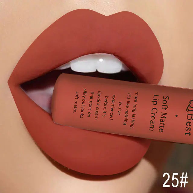 Close-up of lips wearing a matte reddish-brown shade while lightly biting a tube of Léa Beauty & Cosmetics Matte Non-Stick Liquid Lip Gloss - Long-Lasting Finish; the number 25# is visible in the corner.