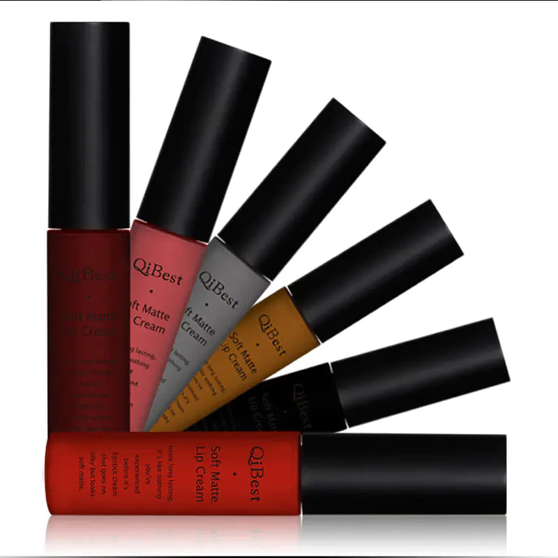 Six Léa Beauty & Cosmetics Matte Non-Stick Liquid Lip Glosses in red, pink, nude, brown, gray, and black are fanned out on a white background, showcasing stylish long-lasting color with a smooth matte finish.