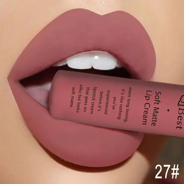 Close-up of lips with Léa Beauty & Cosmetics Matte Non-Stick Liquid Lip Gloss - Long-Lasting Finish in shade 27#, a matte mauve color, tube labeled “Soft Matte Lip Cream,” held gently between slightly parted lips.