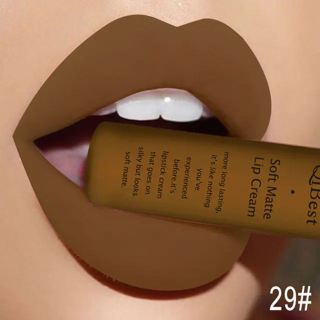 A close-up of lips wearing matte brown lipstick holds a tube of Léa Beauty & Cosmetics Matte Non-Stick Liquid Lip Gloss - Long-Lasting Finish between the teeth, with details shown and 29# marked in the lower right corner.